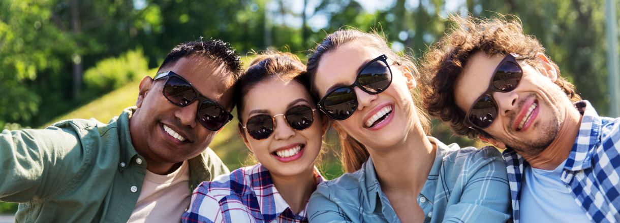 Quatre amis à lunettes de soleil qui prennent un selfie